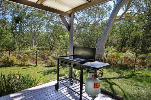 a barbecue grill on a deck in a yard at Wildwood I Pet Friendly I 5 Mins to Beach in Callala Beach