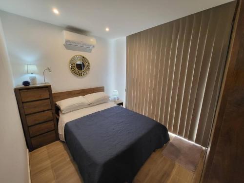 um quarto com uma cama, uma cómoda e uma janela em Seafront Apartment No 10 Marsalforn em Marsalforn