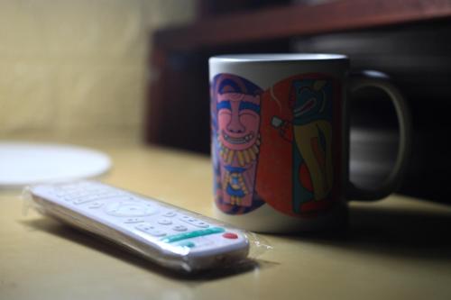 a remote control sitting next to a coffee cup at Pearl B&B in Jinsha