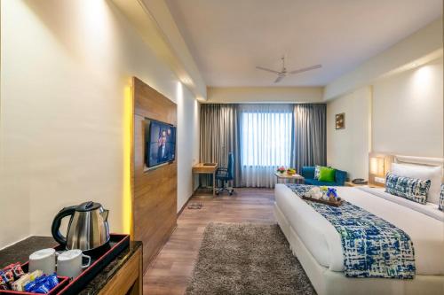 a hotel room with a bed and a living room at Lords Inn Jaipur in Jaipur