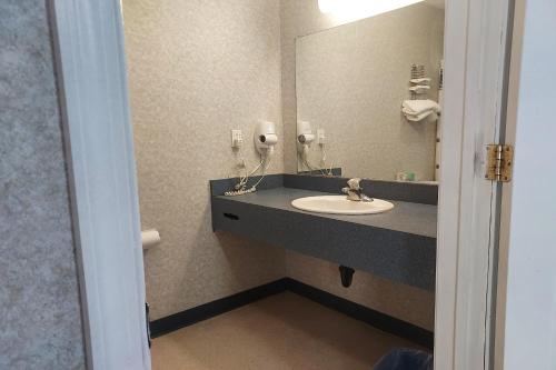 a bathroom with a sink and a mirror at Studio Inn and Suites in Galloway