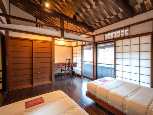 a room with two beds and a chair in it at 慶有魚·宫川(Kyotofish·Miyagawa)*宫川町歌舞练场*近衹园*京都民宿认证 in Kyoto
