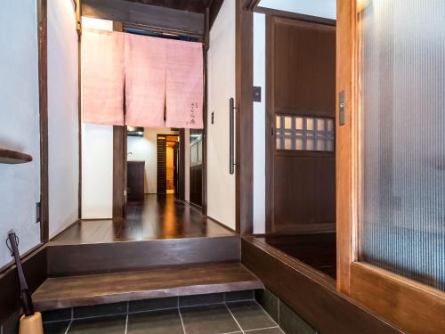 a hallway with a wooden door and a stairway at 慶有魚·宫川(Kyotofish·Miyagawa)*宫川町歌舞练场*近衹园*京都民宿认证 in Kyoto