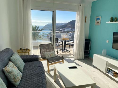 a living room with a couch and a table with a view at Casa Aita - refurbished apartment with unparalleled sea view in Mogán