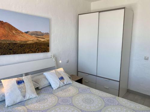 a bedroom with a bed and a painting on the wall at Casa Aita - refurbished apartment with unparalleled sea view in Mogán