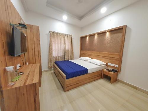a bedroom with a bed and a flat screen tv at Stay Court - Business Class Hotel - Near Central Railway Station in Chennai