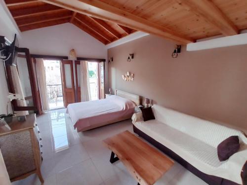 a bedroom with a bed and a couch and a table at Main square apartment in Symi