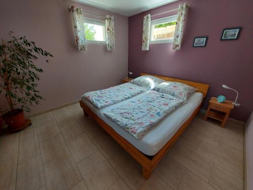 a bedroom with a bed and two windows at Ferienwohnung Sonne 11 in Weisbrunn