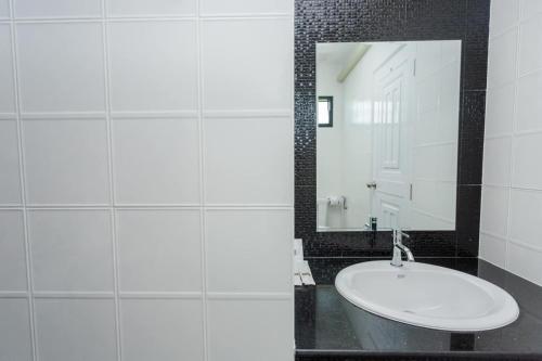 uma casa de banho com um lavatório branco e um espelho. em Get Sleep @ท่าศาลา em Ban Pho Tai