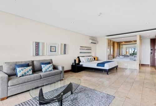 a living room with a couch and a bed at Santai Resort - Holiday Management in Kingscliff
