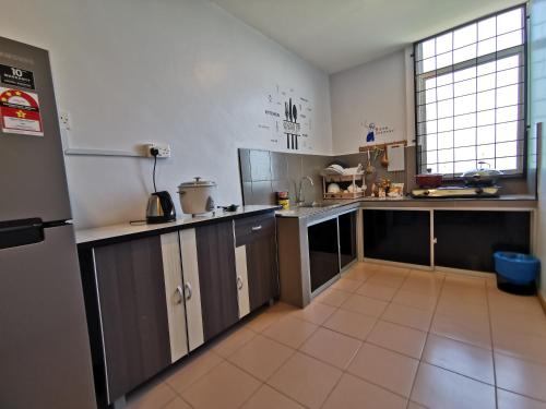 a large kitchen with white cabinets and a large window at Garden in Semporna