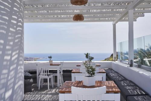 a balcony with a table and chairs and the ocean at Apanemo Hotel & Suites in Akrotiri