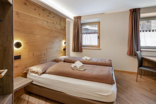 una camera da letto con un letto e una parete di legno di Ice Mountain Planet Suite House a Livigno