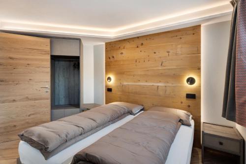 uma fila de camas num quarto com paredes de madeira em Rock Mountain Planet Suite House em Livigno