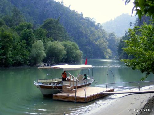 a boat is docked on a dock on a river at Murat Pasha Mansion in Dalyan