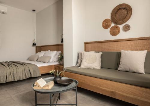 a bedroom with a bed and a couch and a table at Paradise Elegant Apartments - Perfect escape on the beach in Alykes