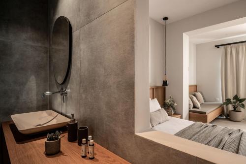 a bathroom with a mirror and a bed in a room at Paradise Elegant Apartments - Perfect escape on the beach in Alykes