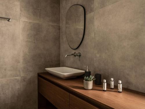 a bathroom with a sink and a mirror at Paradise Elegant Apartments - Perfect escape on the beach in Alykes