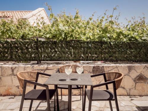 a table with two chairs and two wine glasses at Paradise Elegant Apartments - Perfect escape on the beach in Alykes