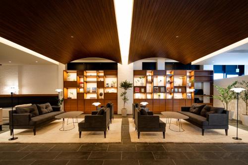 a lobby with couches and chairs in a building at Via Inn Prime Hiroshima Shinkansenguchi in Hiroshima