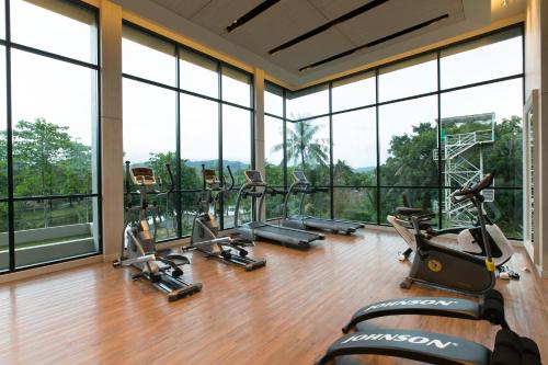 a gym with a row of treadmills and ellipticals at Sugar Palm Residence in Phuket Town