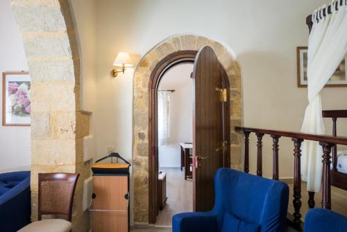 an archway leading to a hallway with a blue chair at Spilia Village Hotel & Villas in Spiliá
