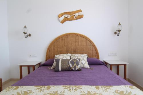 Un dormitorio con una cama con sábanas y almohadas púrpuras. en Casa La Rijana 8, en Almuñécar
