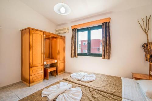 sypialnia z łóżkiem, komodą i oknem w obiekcie Mirage Arillas Studio Type A6 w mieście Arillas