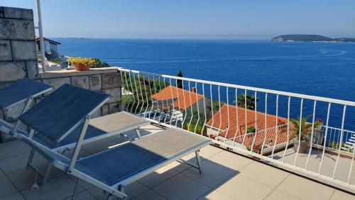 a balcony with two chairs and a view of the ocean at Apartmani Matea in Zaton