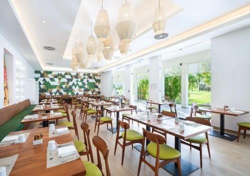 a restaurant with wooden tables and chairs and windows at St Martin Beach Resort & Spa in Anse Marcel 