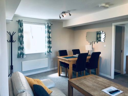 uma sala de estar com uma mesa e cadeiras e um sofá em Two Warehouse Apartments em Ulverston