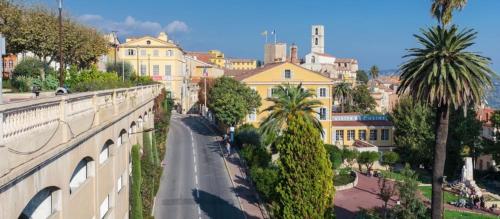 a view of a city street with palm trees and buildings at SOLEIL ZEN in Grasse