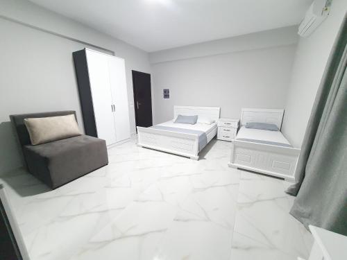 een witte woonkamer met een bank en een stoel bij IL MIO in Ksamil