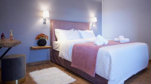 1 dormitorio con 1 cama grande con sábanas blancas en Apartments Gonies - Artemis, en Goníai