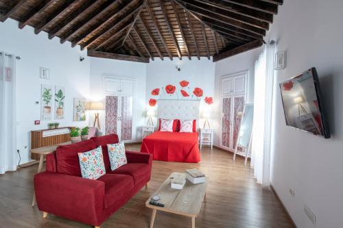 a living room with a red couch and a bed at Casa Emblemática Salgado in Santa Cruz de la Palma