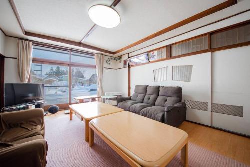 a living room with a couch and a table at GUESTHOUSE CHIYOGAOKA in Asahikawa