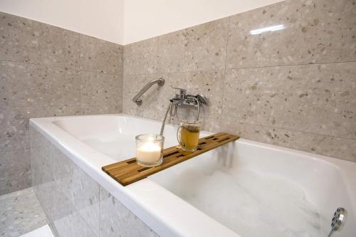 a bathroom with a bath tub with two candles on a tray at Apartment Derossi in Umag