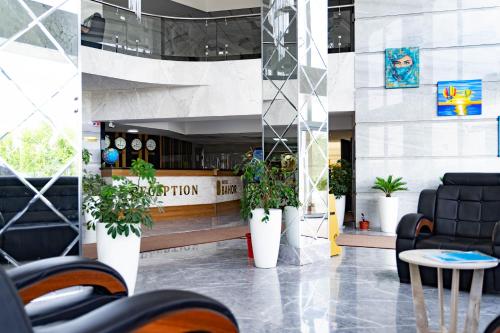 a lobby with a bar and chairs and plants at Reikartz Bahor Bukhara in Bukhara