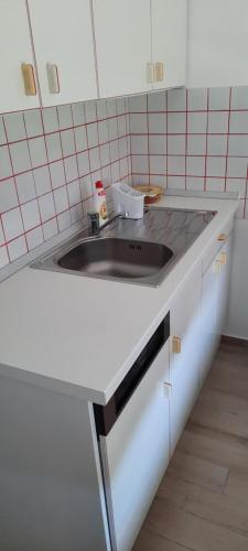 a kitchen with a sink and a white counter top at Kati Villa in Vonyarcvashegy