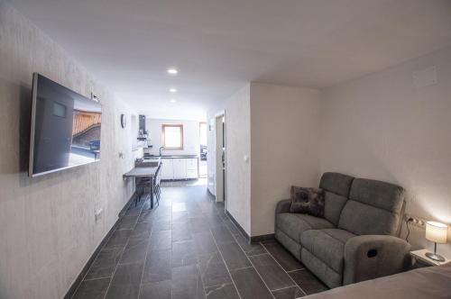 a living room with a couch and a kitchen at Old Mill House in Bohinj