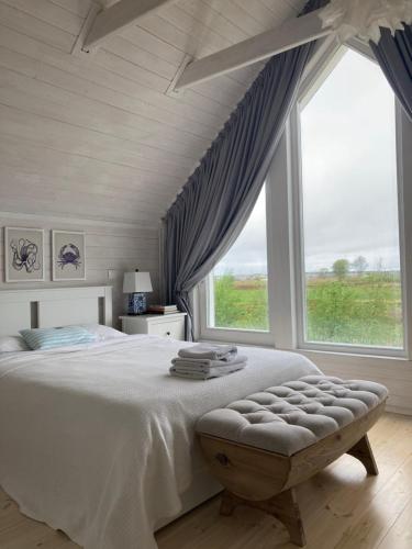 a bedroom with a large bed and a large window at Apartamenty Pogodna in Łeba