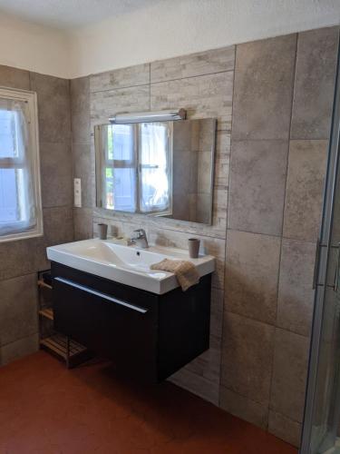 une salle de bain avec un lavabo et un miroir dans l'établissement Prime Rose, à Saint-Aygulf