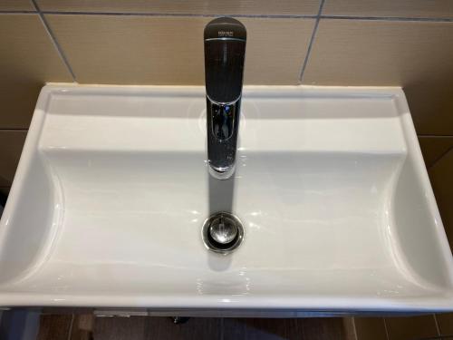 a white sink with a black faucet in a bathroom at Angela Hotel & Apartments in Gouvia