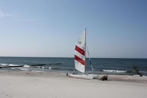 a sail boat on a beach with the ocean at Hotel Am Alten Strom in Warnemünde