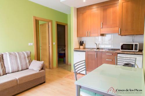 a kitchen and a living room with a couch and a table at Apartamento el Peral A in Colombres
