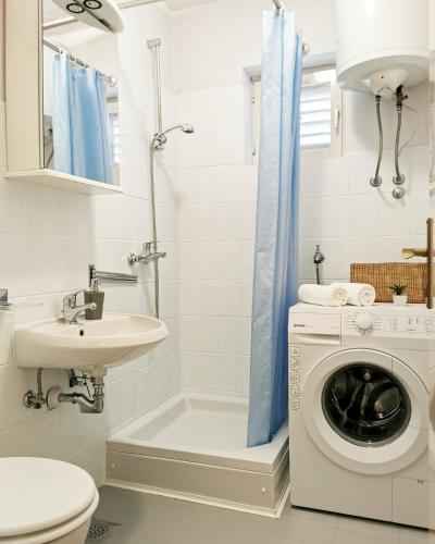 ein Badezimmer mit Waschmaschine und Waschbecken in der Unterkunft Sealine in Podstrana