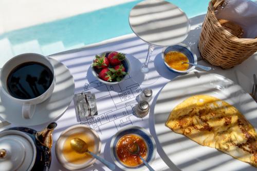 a table topped with plates of food and a cup of coffee at Wind Tales in Ermoupoli