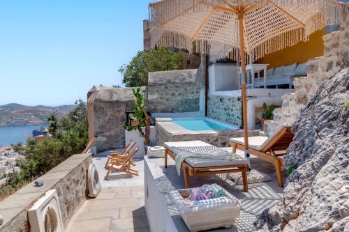 a house with a swimming pool and an umbrella at Wind Tales in Ermoupoli