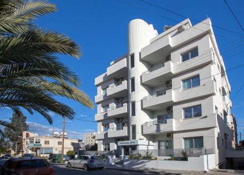 a white building with cars parked in front of it at Myrtiana Apartments in Nicosia