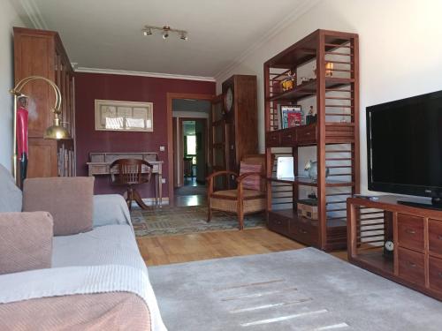 un soggiorno con divano e TV di Babilonia, apartamento en Llanes tranquilo y céntrico a 150m de la playa del Sablón a Llanes